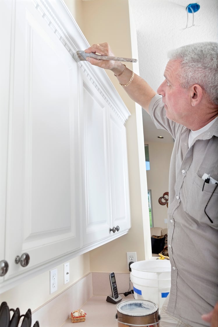 Construction: Handyman painting cabinet trim